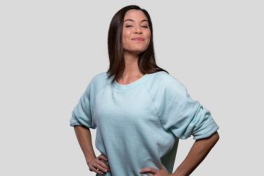 A woman wearing a blue sweater appears joyful.
