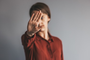 Young woman showing gesture stop. Violence against women concept. Young female protesting against domestic violence and abuse, bullying, saying no to gender discrimination