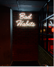 a brick wall with bad habits written in it