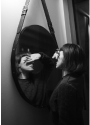 a woman is looking in the mirror hiding her face