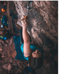 a woman is climbing on a rock with a rope