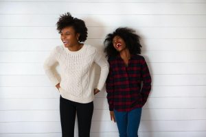 Two women are standing next to eachother, laughing, They may be friends. Therapy for mood disorders in Woodland Hills CA can help with coping with depression using cognitive behavioral therapy.