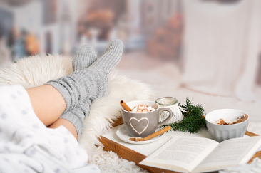 Image shows a woman with her feet up on a table, with hot chocolate and a book next to her. This image may represent a self care routine. 
    
    Anxiety therapy and counseling in Woodland Hills, CA can help you feel connected. Meet with an online marriage counselor in Woodland Hills, CA with online therapy in California here.  90077 | 91324 | 91364 | 91411 | 91436