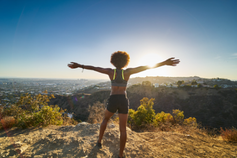 In this image we see a black woman on a hike, looking at the city few holding her arms spread wide. Feel confident and powerful in setting boundaries with those around you. Individual therapy is available in person or virtually at our Los Angeles, CA therapy office.
