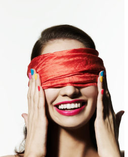 In this image we see a smiling woman with a red bandana covering her eyes. Both of her hands are on the sides of her face and she has colorful nail polish on. Therapy is offered at our Los Angeles, CA therapy office for virtual or in person therapy sessions. 91364 | 91307 | 91356