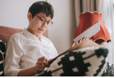 The image shows a woman with glasses doing research with her ipad and notebook. It is important to educate yourself on your partners mental health in order to help them. In person and virtual therapy is offered at our Woodland Hills, CA therapy office.