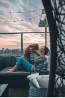 Woman is sitting on her rooftop patio on a couch holding her dog in the air, giving the dog a kiss. It is important to take care of yourself and be patient in order to move forward from your struggles. Treatment is available virtually and online at our Woodland Hills, CA location. 91364 | 91307 | 91356