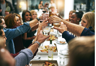 a group of people having dinner and raising their glass to celebrate. If you struggle with social anxiety in large groups and have difficulty attending social gathering, our therapist can help using CBT skills to do exposure therapy and teach you social skills. 91307