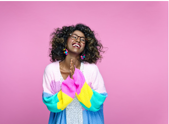 A black woman is standing in front of a pink background, wearing a colorful cardigan. She is wearing glasses and smiling while putting her hands together in front of her. Being thankful for your failures can help you realize that they are useful in your growth process. In person and virtual therapy is available at our Woodland Hills, CA therapy practice. 91364 | 91307 | 91356