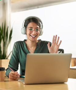 a woman in her 20s speaking at a zoom meeting and waving her hand to the screen and smiling. Do you feel disconnected from others during mother's day? Our CBT therapist can help you explore relationship issues so you can feel better about yourself. 