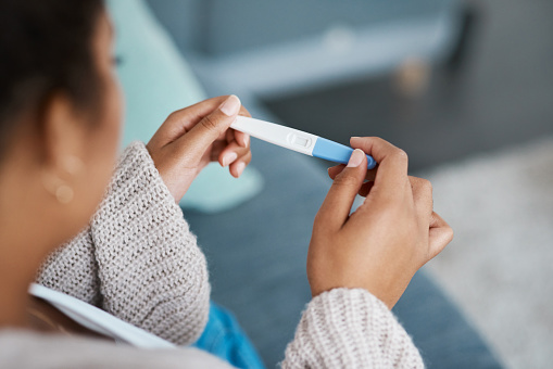 Cropped shot of an unrecognizable woman taking a pregnancy test at home