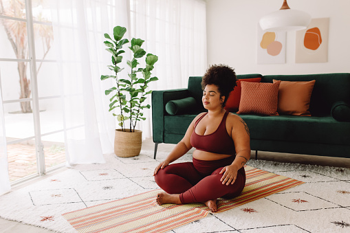 Body positive woman doing mindfulness workout at home. Beautiful female in sports wear practicing meditation at home. Therapy for depression can help with coping skills to improve mood, functioning, and relationships. You can also get help for anxiety counseling in Los Angeles, CA and with online therapy in California.  91364