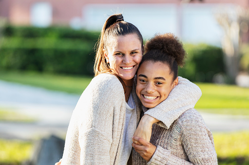 A mixed race 13 year old teenage girl standing in the front yard with her step-mother, arms around each other, holding hands, smiling at the camera. have a strong connection with your teen.
You can feel better about your relationship with your teen with a skilled CBT therapist in Woodland Hills, CA via online therapy in California. 91364 | 91307 | 91356 | 91301 | 91302 | 91372 | 91367 