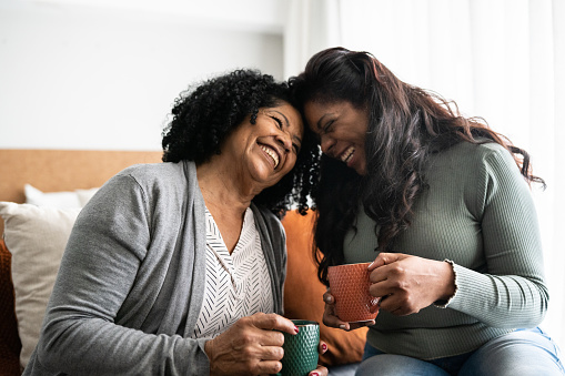 Bonding moment between an African-American mother and daughter at home as they are having tea and laughing together. If family relationships get stressful during the holidays, individual or couple's therapy can help you learn the skills you need to manage stress and relationship conflicts.  91406 | 91405 | 91343 | 91324 | 91304 