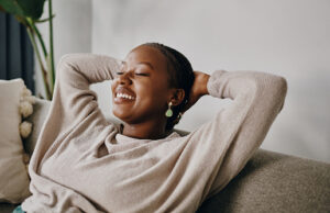 A women smiling and lying on a couch