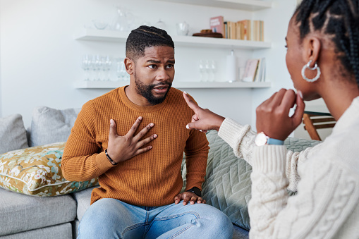 An African-American couple is fighting in their living room while the wife is pointing fingers at her husband. If you are struggling with blaming and can never resolve issues in your marriage, a couple's therapist can teach you more effective communication skills in our office in Woodland Hills, CA. 91364
