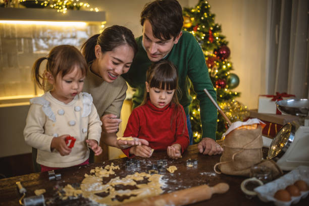 A biracial family is baking cookies during Christmas time together. There is a Christmas tree behind them, as they use cookie cutters to bake cookies.

balance during the holiday season