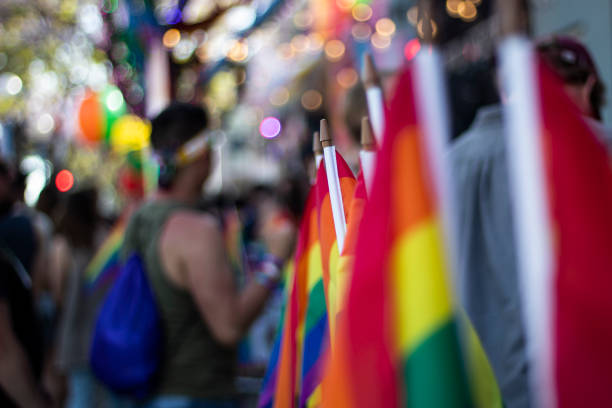 In this image we see an LGBTQ parade with LGBTQ flags all around.