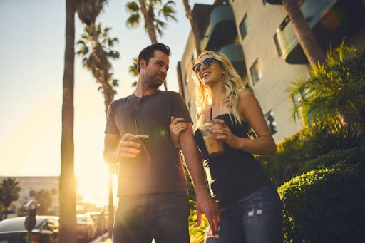 trendy attractive couple walking together with coffee in los angeles with unnecessarily tilted composition